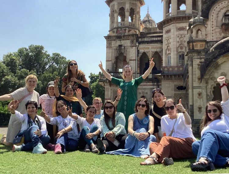 Project group cheering in front of an old church or temple.