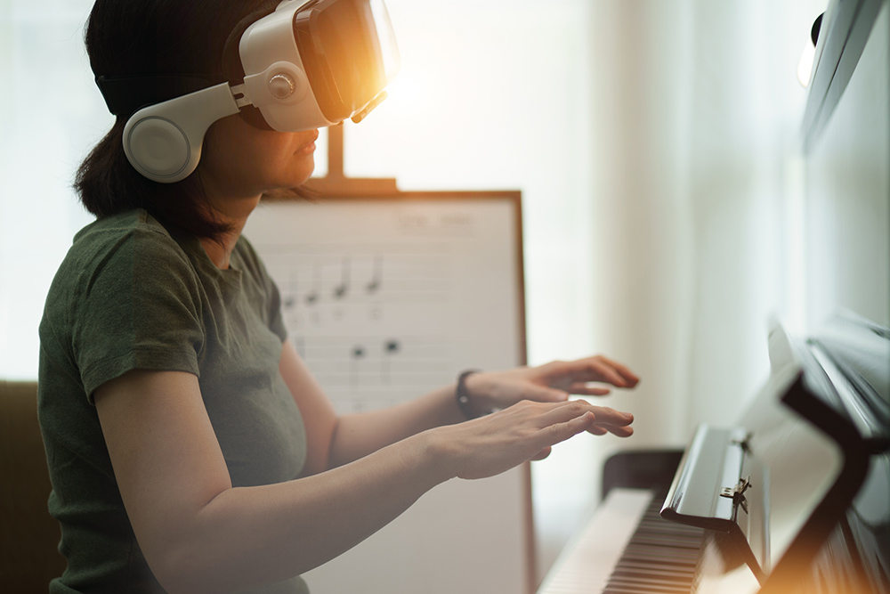 Henkilö on soittamassa pianoa VR-lasit päässään.