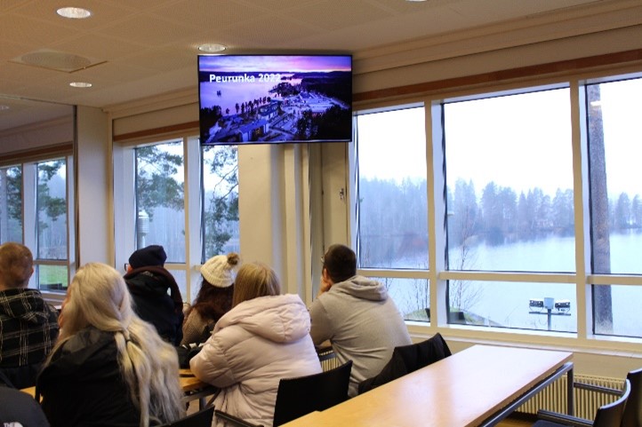 Students listening to a speech in Peurunka conference room with a view of the snowy central finland visible in the background
