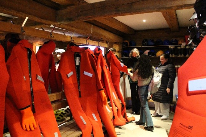 Red rafting suits and students looking at them